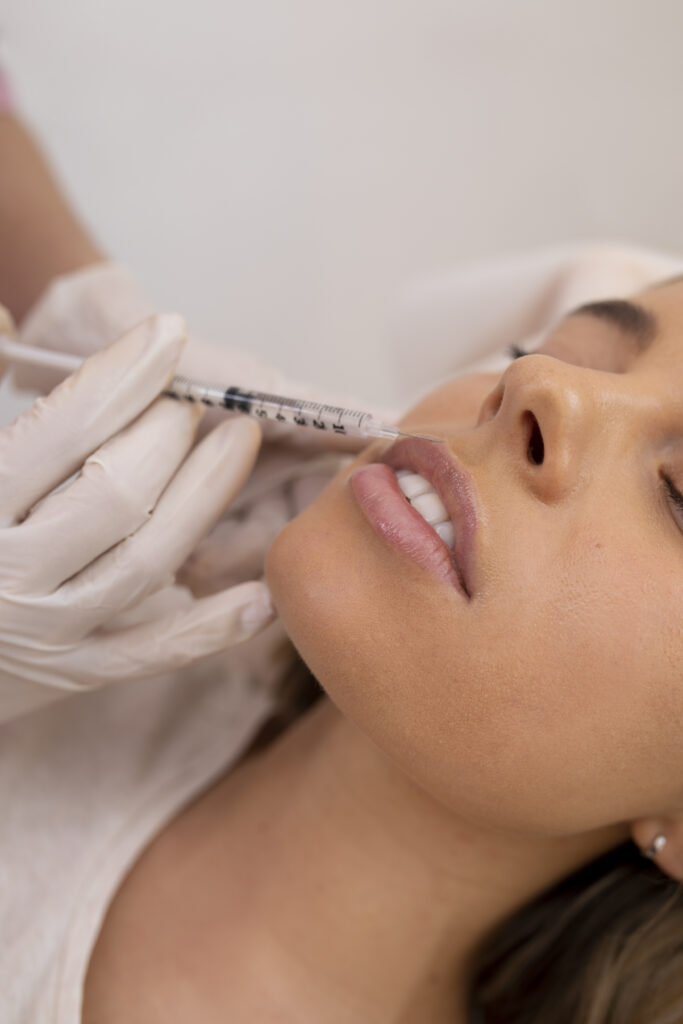 Médico estético realizando aplicación de ácido hialurónico para armonización facial y mejora de contornos del rostro.